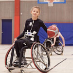 Bild på ung tjej som spelar rullstolsbasket och använder Mollii