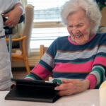 äldre kvinna som använder digitala upplevelser på surfplatta